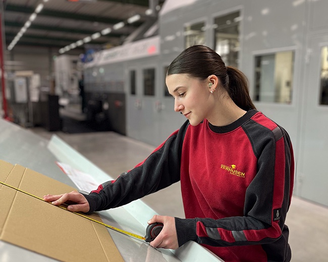 Eine Packmitteltechnologin ermittelt die Maße des Zuschnitts im Rahmen einer Qualitätskontrolle Eine Packmitteltechnologin ermittelt die Maße des Zuschnitts im Rahmen einer Qualitätskontrolle