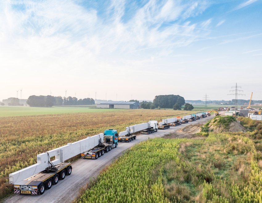 LKW-Konvoi liefert Betonpfeiler für automatisches Papierrollenlager